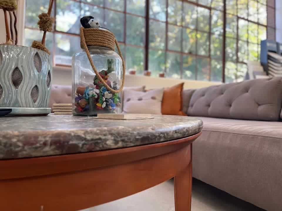 Living room with a round coffee table, a jar of toys, and a beige sofa.