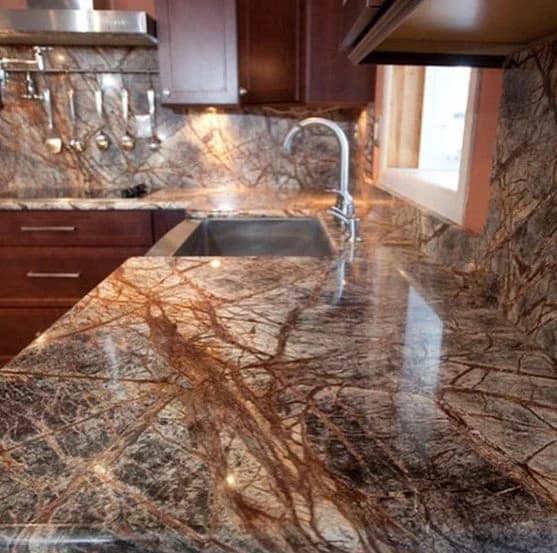 Kitchen with brown marble countertops and backsplash, and a modern sink.