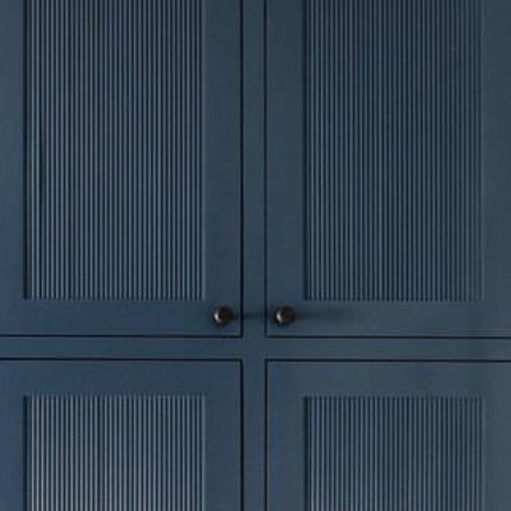 Detailed shot of dark blue fluted cabinetry with round handles.